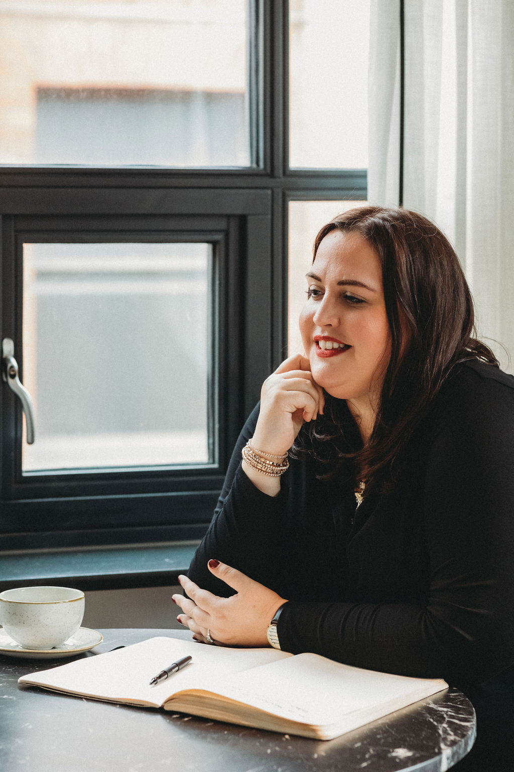 A close up image of Alice holding a stack of books relating to therapy.